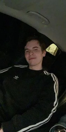 Paul in a black tracksuit jacket, smiling softly